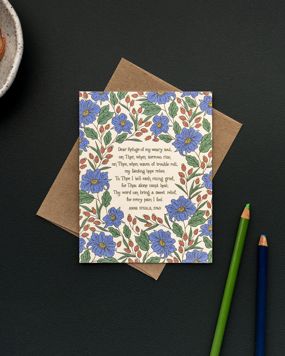 The Dear Refuge of My Weary Soul hymn greeting card, framed by thunder blue and burnt sienna floral against a moonstone background, is styled with a recycled kraft paper envelope, colored pencils, and ceramic dish.