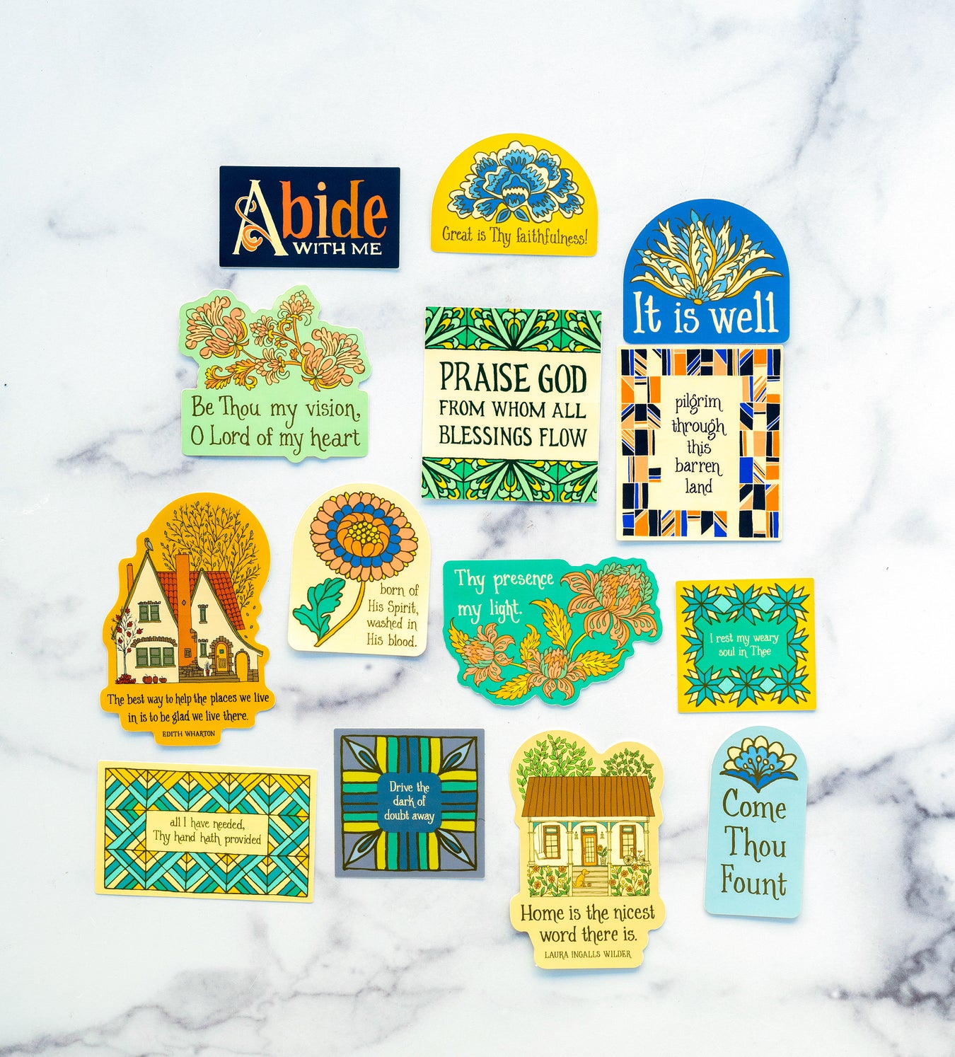 The set of 14 stickers by Little Things Studio, featuring all of our stickers — hymn texts, inspiring quotes, intricate illustrations, and vivid colors. Shown here against a marble backdrop.