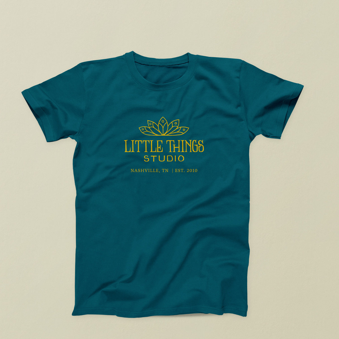 Teal shirt with Little Things Studio logo in yellow