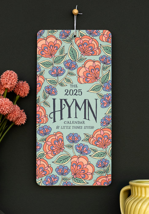 Celebrate 2025 with hymns both ancient and modern, bold floral patterns, and intricate hand-lettering, shown styled with a ceramic jug and flowers against a charcoal wall.