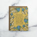 The Be Thou My Vision hymn greeting card, framed by rainforest green and stormy blue colored florals against a saffron background, shown with a kraft paper envelope against a marble background.