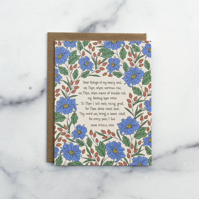 The Dear Refuge of My Weary Soul hymn greeting card, framed by thunder blue and burnt sienna floral against a moonstone background, shown with a recycled kraft paper envelope against a marble background.