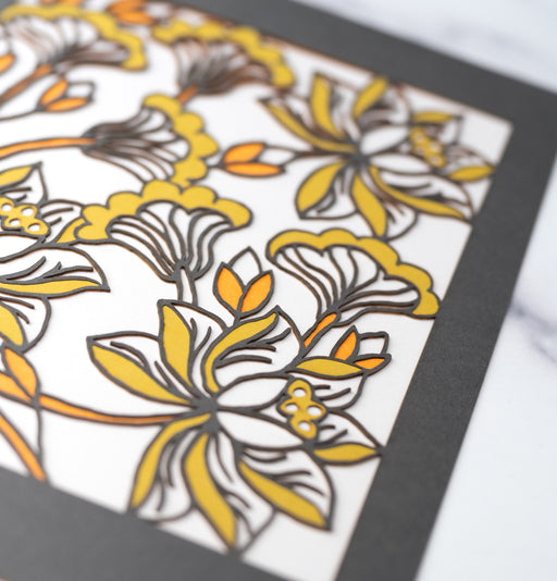 Detail image of the Layered Floral Papercut “Audrey” (Light Gray) which is made using cardstock in hues of dark gray, orange fizz, mustard, and light gray.