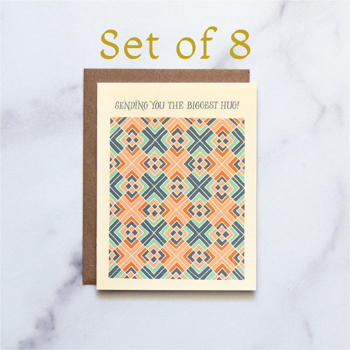 The Biggest Hug Greeting Card features a hand illustrated geometric pattern in blues and corals— a beautiful greeting card pictured against a white marble background.