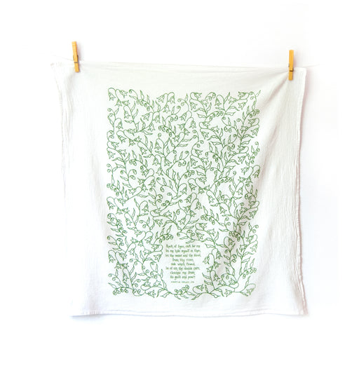 Rock of Ages hymn tea towel is printed in a fresh grass green and features hand illustrated floral design surrounding the hand-lettered hymn text. Shown unfolded and hanging with clothes pins.