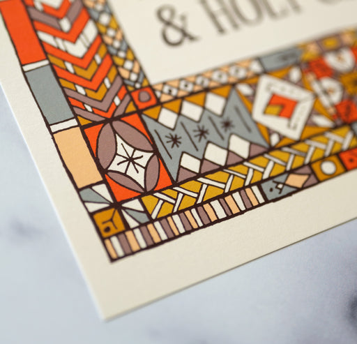 Doxology hymn art print — biblical wall art showcasing a close-up of the muted blue, red, and yellow stained glass border that surrounds the hand-lettered text