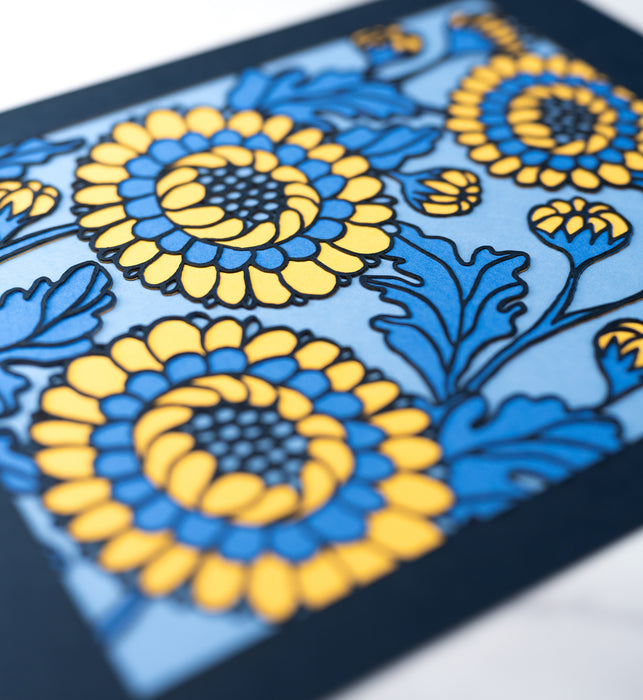 Detail image of the Layered Floral Papercut “Lou” (Cornflower), which is made using cardstock in hues of flag blue, Prussian blue, light gold, cornflower.