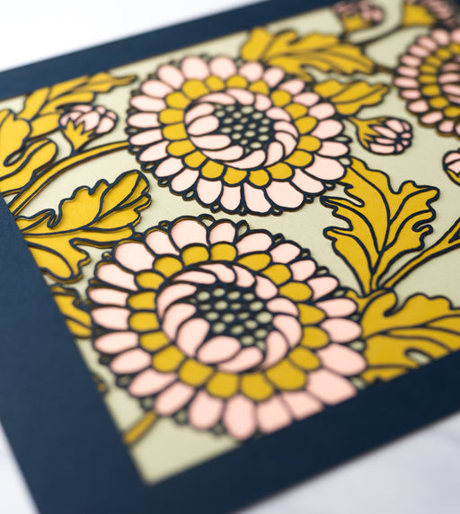 Detail image of the Layered Floral Papercut Lou in Kiwi, which is made using cardstock in hues of flag blue, mustard, salmon, and kiwi.