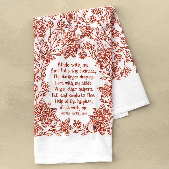 Abide with Me hymn tea towel printed in country red, pictured folded against a khaki background