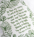 Text and illustration detail of the Be Thou My Vision tea towel, printed in forest green and features hand lettered text surrounded by illustrated botanicals.