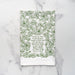 The Be Thou My Vision hymn tea towel is printed in forest green and features lyrics from the hymn, shown folded against a marble backdrop.