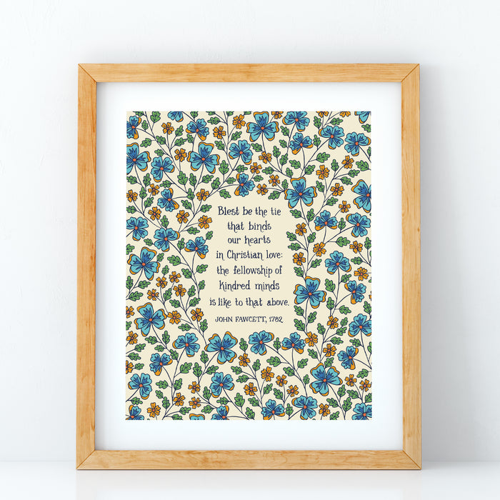 Blest be the Tie hymn art print, featuring hand lettered text offset by delicate hand illustrated floral designs, printed on a cream background, displayed in light wood frame against a white background.