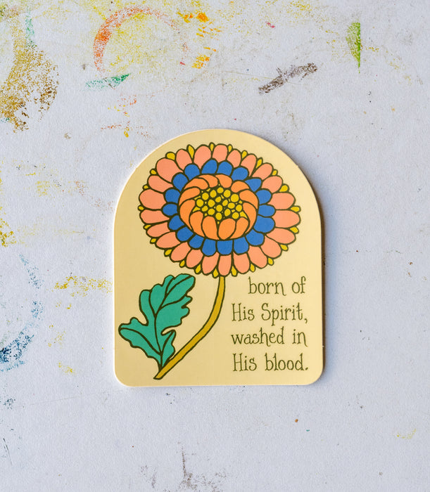 The "Blessed Assurance" hymn sticker features an arched window silhouette, colorful floral and lyrics, "born of his Spirit, washed in His blood." Shown against a worktable background.