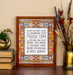 Doxology hymn art print — biblical wall art showcasing a close-up of the muted blue, red, and yellow stained glass border that surrounds the hand-lettered text, styled alongside books, vase with dried flowers and a brass swan.