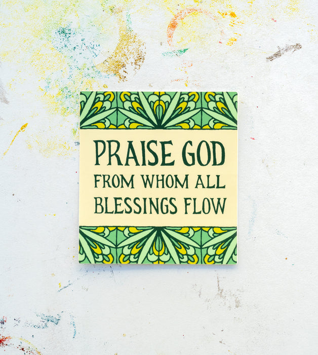 The "Doxology" hymn sticker features the opening line of the Doxology in hand lettered text against a cream background with a mint green floral motif. Shown here against a white worktable background.