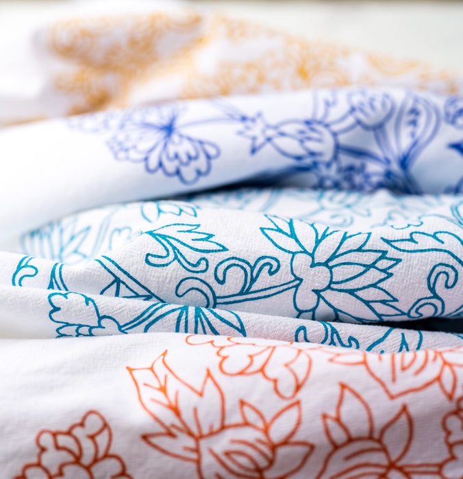 This complete set of our floral tea towels features our unique floral illustrations in colorful hues to brighten up any home, shown casually folded and grouped together.