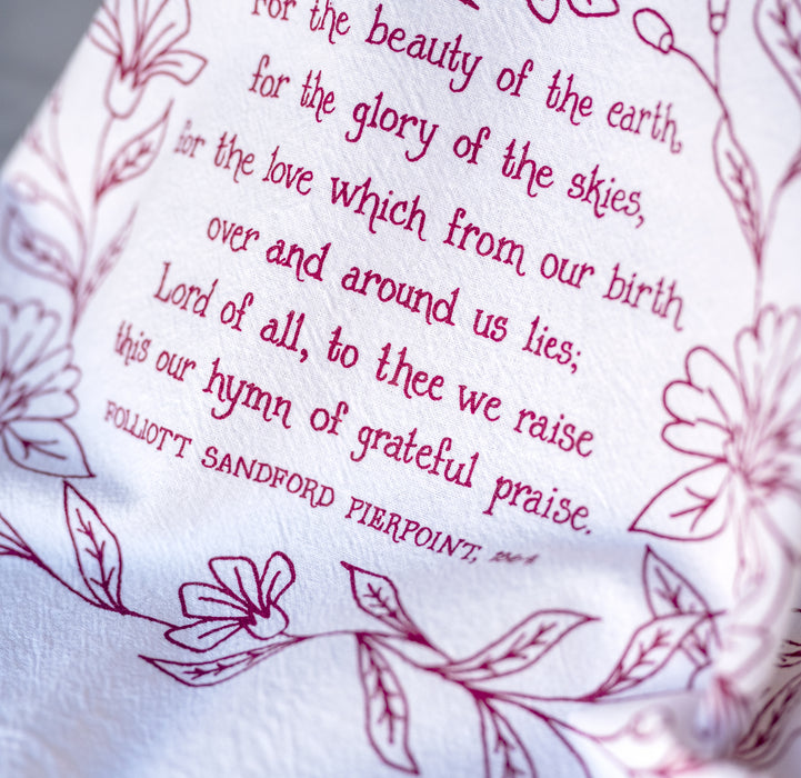 Detail image of the text and illustration of the For the Beauty hymn tea towel, printed in pink plum and featuring delicate floral illustrations and hand-lettered lyrics from the hymn.