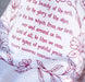 Detail image of the text and illustration of the For the Beauty hymn tea towel, printed in pink plum and featuring delicate floral illustrations and hand-lettered lyrics from the hymn.