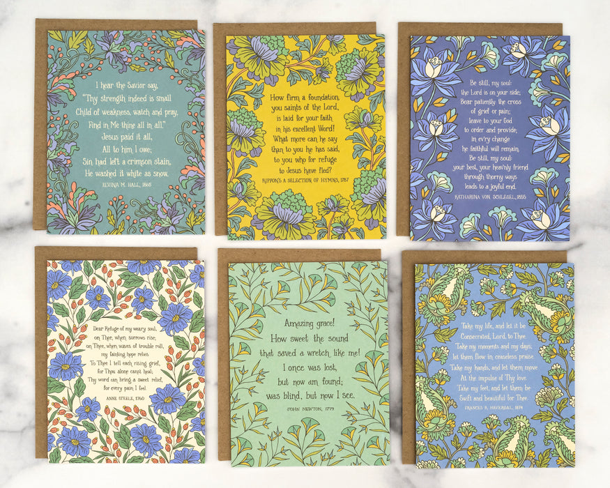 Each of the 6 hymn greeting cards in set "Frances" features a hymn's lyrics on the front and its history on the back, shown here flat with recycled kraft paper envelopes against a marble background.