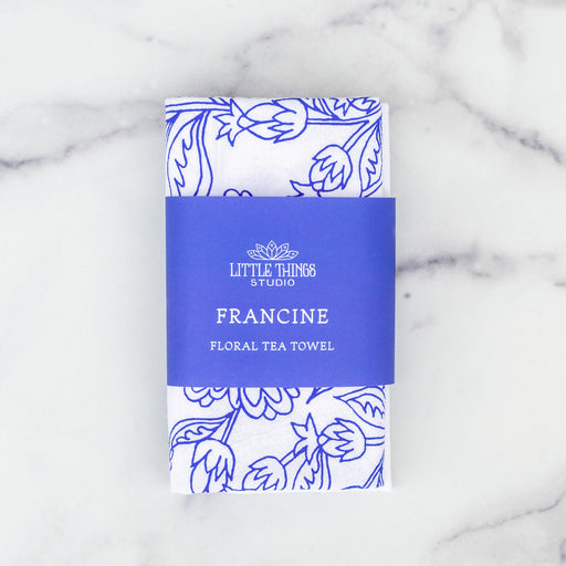 Little Things Studio presents the Francine floral tea towel—a 100% cotton towel made in the USA, featuring airy floral in bright bluebell, shown against a marble backdrop.