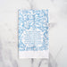 Great Is Thy Faithfulness tea towel is printed in a striking cerulean blue. The hand lettered text is surrounded by illustrated floral design, and the towel is shown folded against a white marble background.