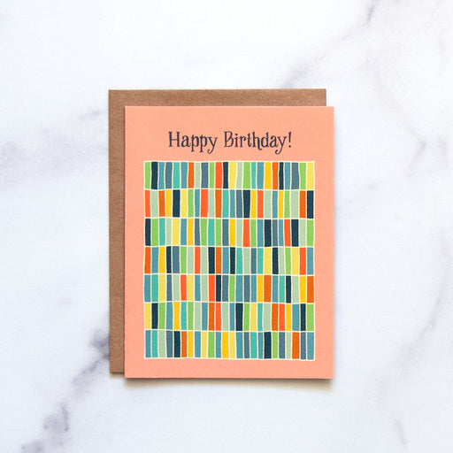 The Happy Birthday! Greeting Card features hand illustrated geometric design in a rainbow of hues against a happy peach background—a blank artsy greeting card ready for your messages of affirmation.