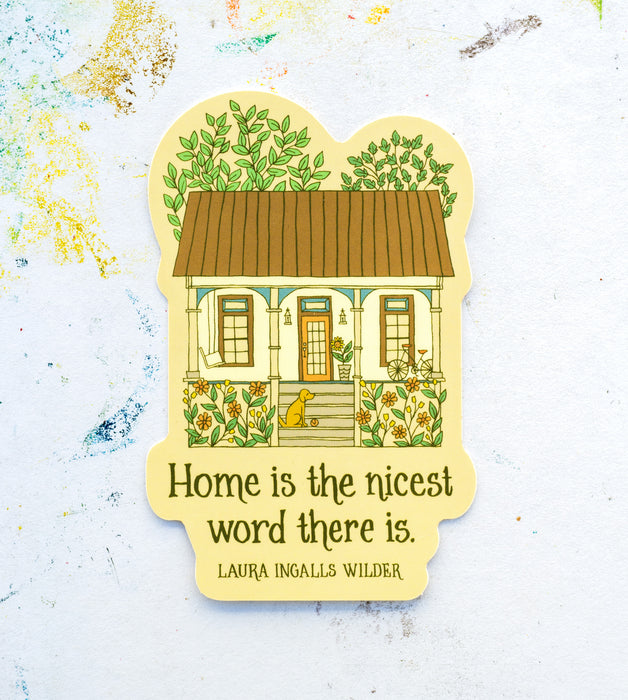 Our new “Home is the nicest word” sticker features the hand lettered quote from Laura Ingalls Wilder coupled with a delightfully detailed house illustration, shown against a white worktable background.