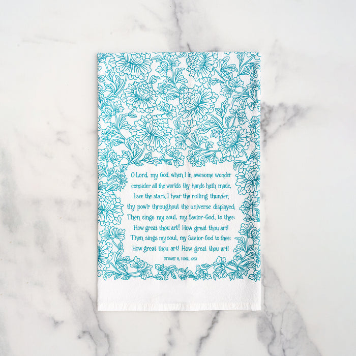 How great thou art tea towel in aqua blue folded on a marble background