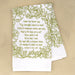 Jesus Paid It All hymn tea towel printed in fresh springtime green, folded and set against a khaki background