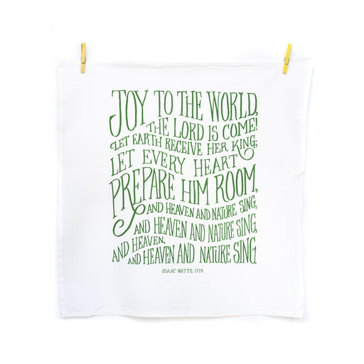 The new "Joy to the World" hymn tea towel features printed, hand-lettered text in winter ivy on a 100% cotton tea towel. Made in the USA. Shown here unfolded and hanging from wooden clothes pins.