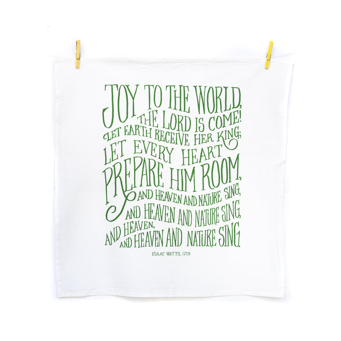 The new "Joy to the World" hymn tea towel features printed, hand-lettered text in winter ivy on a 100% cotton tea towel. Made in the USA. Shown here unfolded and hanging from wooden clothes pins.