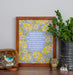 Joyful, Joyful, We Adore Thee hymn art print features bold multi-colored floral against a blue lavender background, displayed in a dark wood frame, styled alongside a tin of greens and ceramic figurines