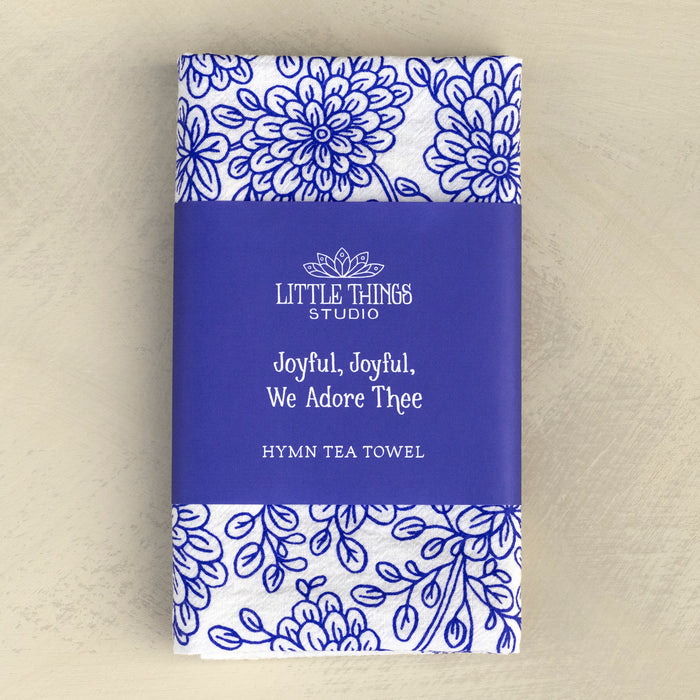 Joyful, Joyful We Adore Thee hymn tea towel features the beloved hymn is printed in blackberry blue, shown folded with a paper belly band for gift giving