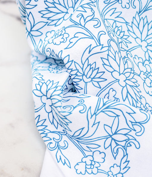 Little Things Studio presents floral tea towels — the Mabel floral tea towel features lively floral illustrations in vibrant turquoise, shown up close with details visible, folded casually against a marble backdrop.