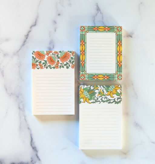 three small notepads with floral illustration and lines for writing