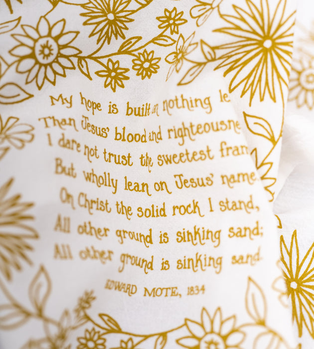 Our "My Hope Is Built" hymn tea towel features whimsical floral illustration and hand lettered hymn text printed in fresh Sicilian green, seen clearly in this close-up image of the towel.