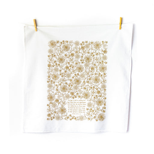 The Hope is Built on Nothing Less tea towel is printed in Sicilian green and features the hand lettered hymn text surrounded by intricate floral illustrations, pictured unfolded and hanging with clothes pins