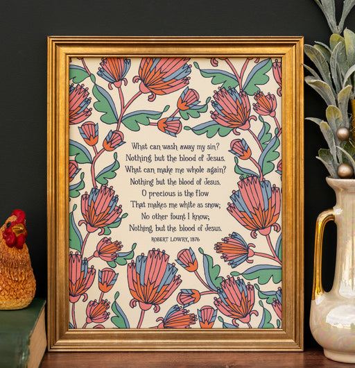 The "My Hope Is Built" hymn art print features the text surrounded by multi-colored florals against an aquamarine background; shown framed and styled with a vase of greens and a figurine.