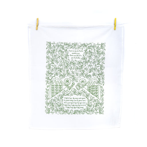 The "O Holy Night" hymn tea towel is hand-lettered with a festive holly border and angel heralds — two sided for use during both Advent and Christmas — and printed in rosemary green on a 100% cotton tea towel. Made in the USA, and shown here unfolded and hanging by wooden clothes pins.