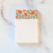 small floral notepad with coral colored floral illustrations and lines, set against a white marble background