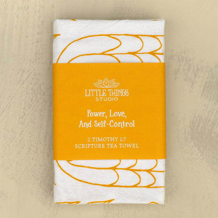 The Power, Love & Self-Control Scripture tea towel is printed in sunflower yellow and features 2 Timothy 1:7; shown folded and wrapped with a belly band for gift giving