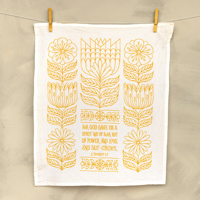 The Power, Love & Self-Control Scripture tea towel is printed in sunflower yellow and features 2 Timothy 1:7; shown hanging with clothes pins