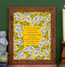 The "Praise to the Lord, the Almighty" hymn art print features hymn text surrounded by white and blue florals against a buttercup yellow. Shown here framed and styled with a ceramic rabbit, books, and a wooden candle holder.