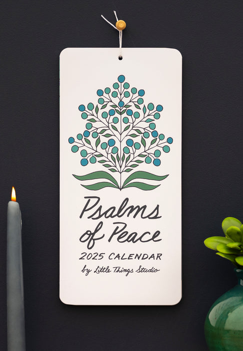 Celebrate 2025 with treasured verses from the Book of Psalms, accented by unique floral patterns and new script-style hand-lettering, shown here styled with greens in a bronze vase alongside an hour-glass.