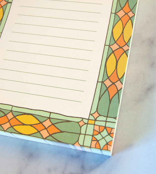 Detail of mini stained glass notepad featuring vibrant border illustration and lined for all your list making or note jotting needs.