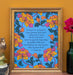 The King of Love My Shepherd Is art print features the cherished hymn surrounded by vibrant jewel-toned floral illustrations against a bright blue background; shown here in a frame and styled with an owl figurine, books, and a flower in a vase.