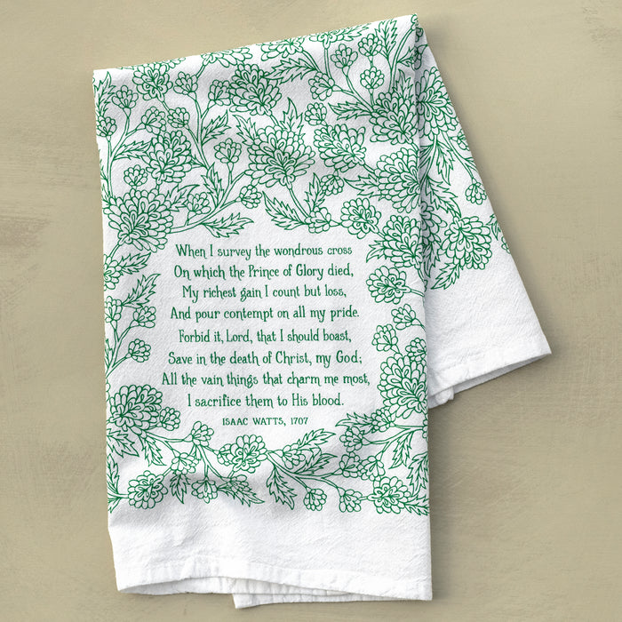 The When I Survey the Wondrous Cross hymn tea towel features the beloved hymn printed in emerald green, shown folded on a khaki background.