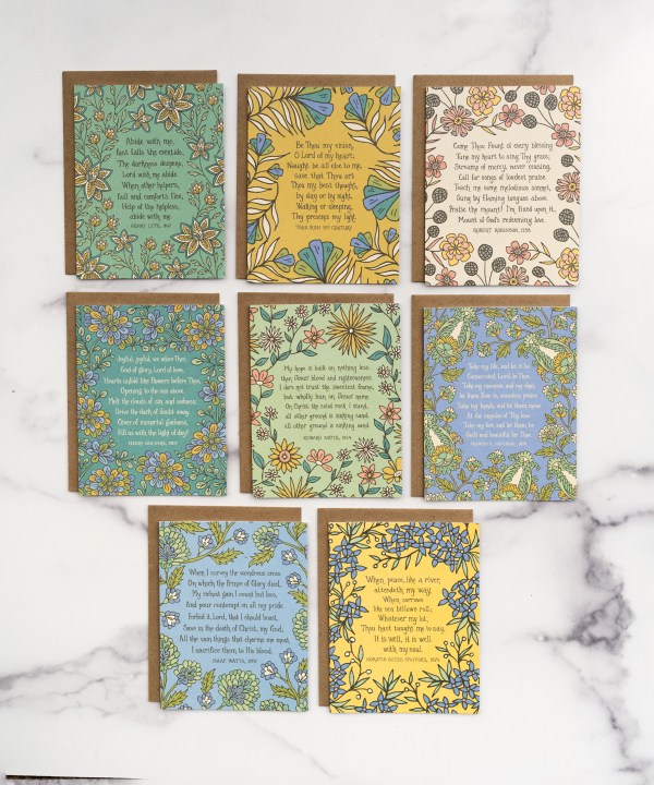 The set of 8 hymn greeting cards "Eventide" contain 8 distinct hymn greeting cards, each featuring the hymn's lyrics on the front and its history on the back. Shown as a set, each with a brown kraft envelope, laid against a marble background.