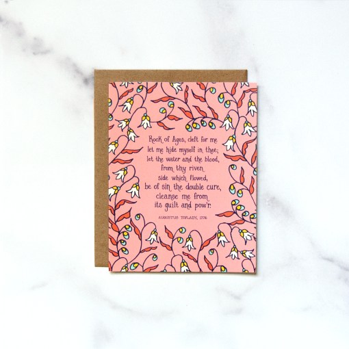 Little Things Studio's "Rock of Ages" Greeting Card features a verse of the beloved hymn text framed by a delicate floral in different shades of pink, shown against a marble backdrop.