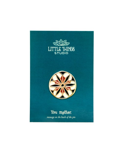 The You Matter enamel pin, shown with its deep teal cardboard backer.